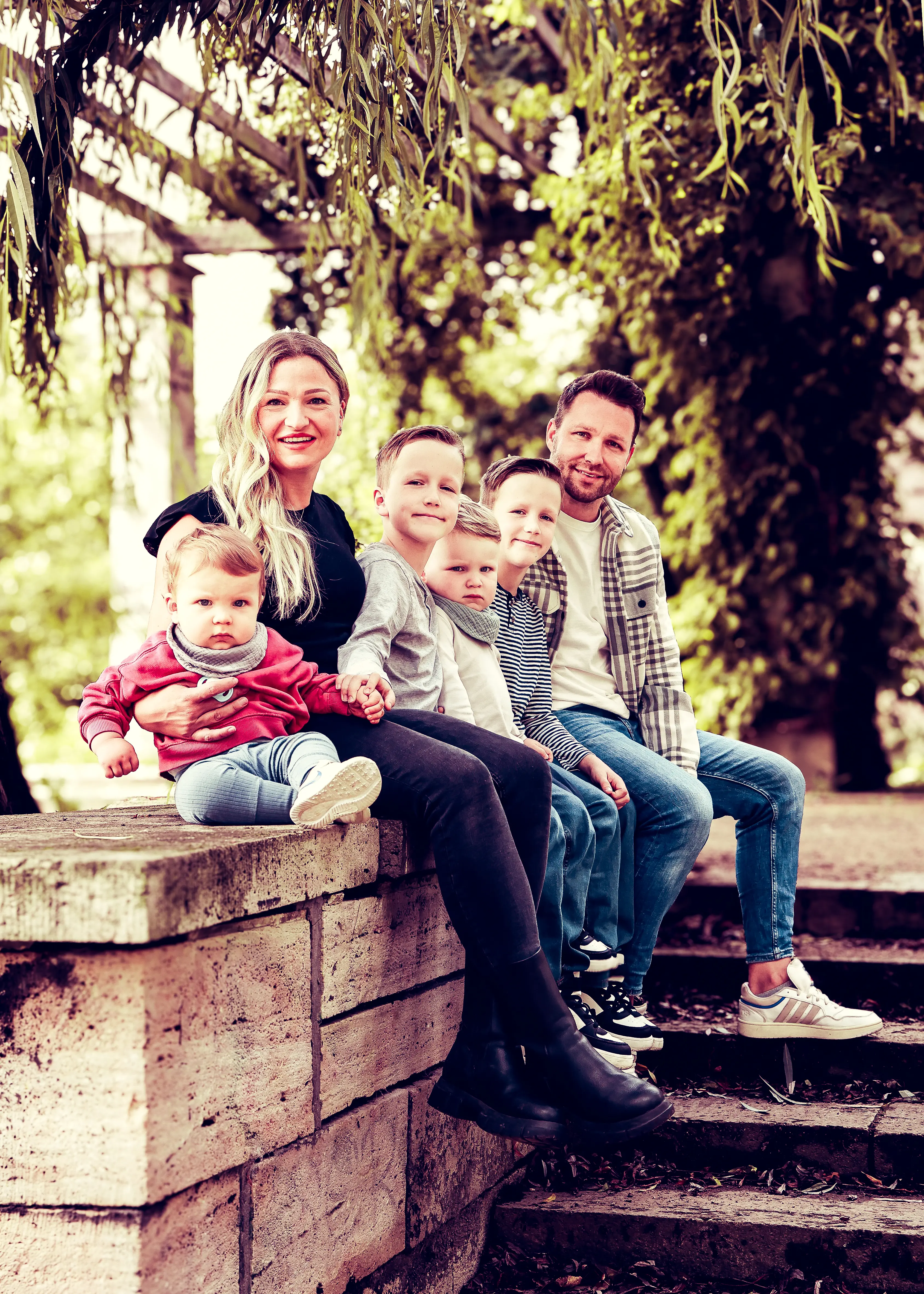Grosse Familie auf Steinmauer im Park