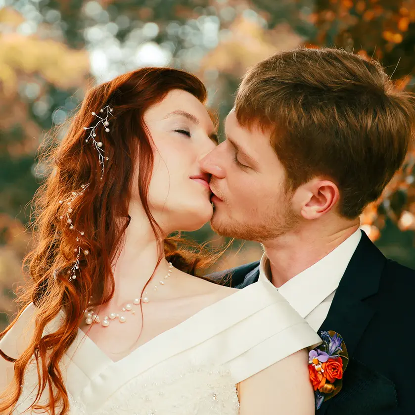 Brautpaar kuesst sich im goldenen Herbstlicht
