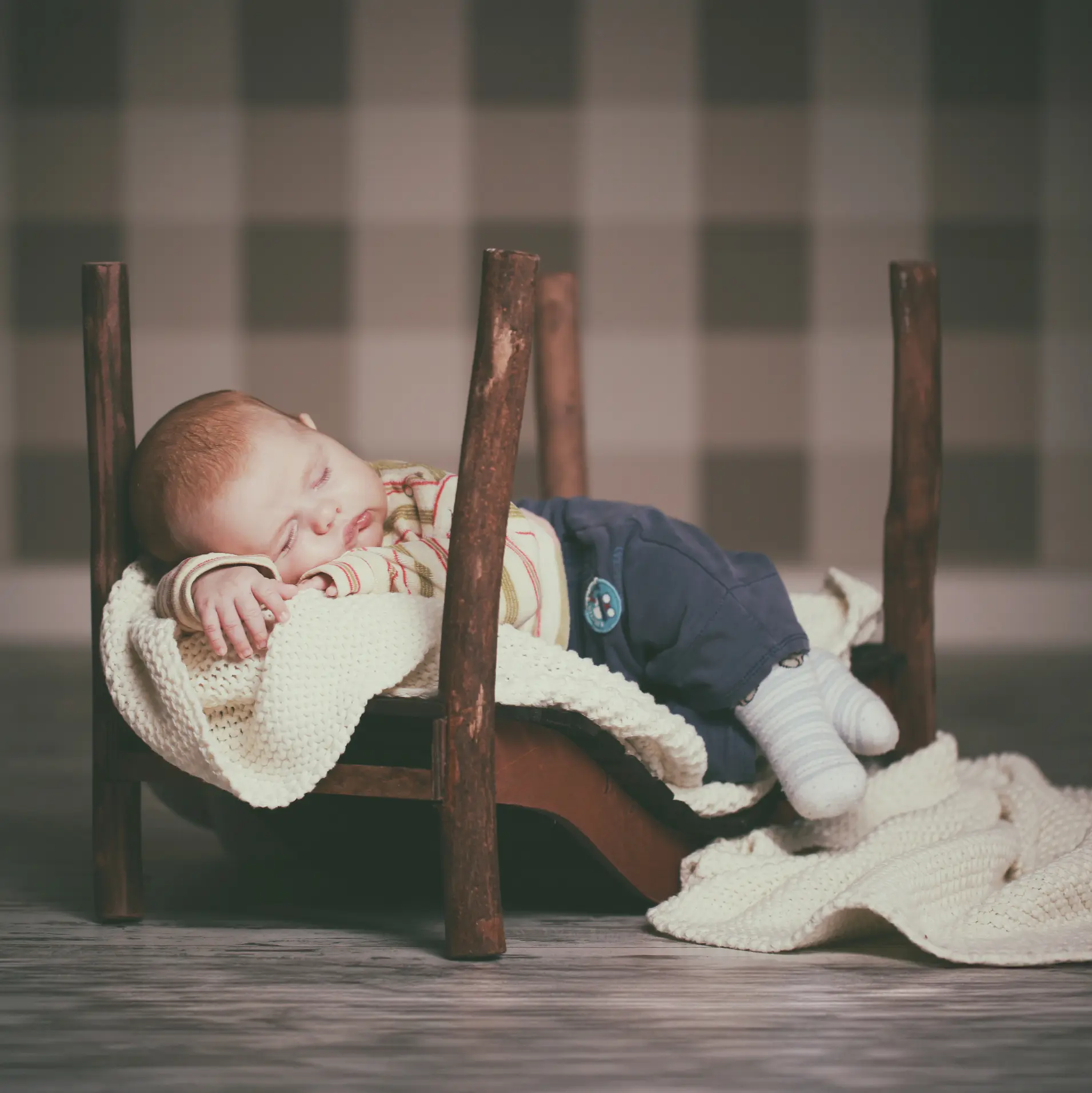 Schlafendes Neugeborenes im Holzbettchen