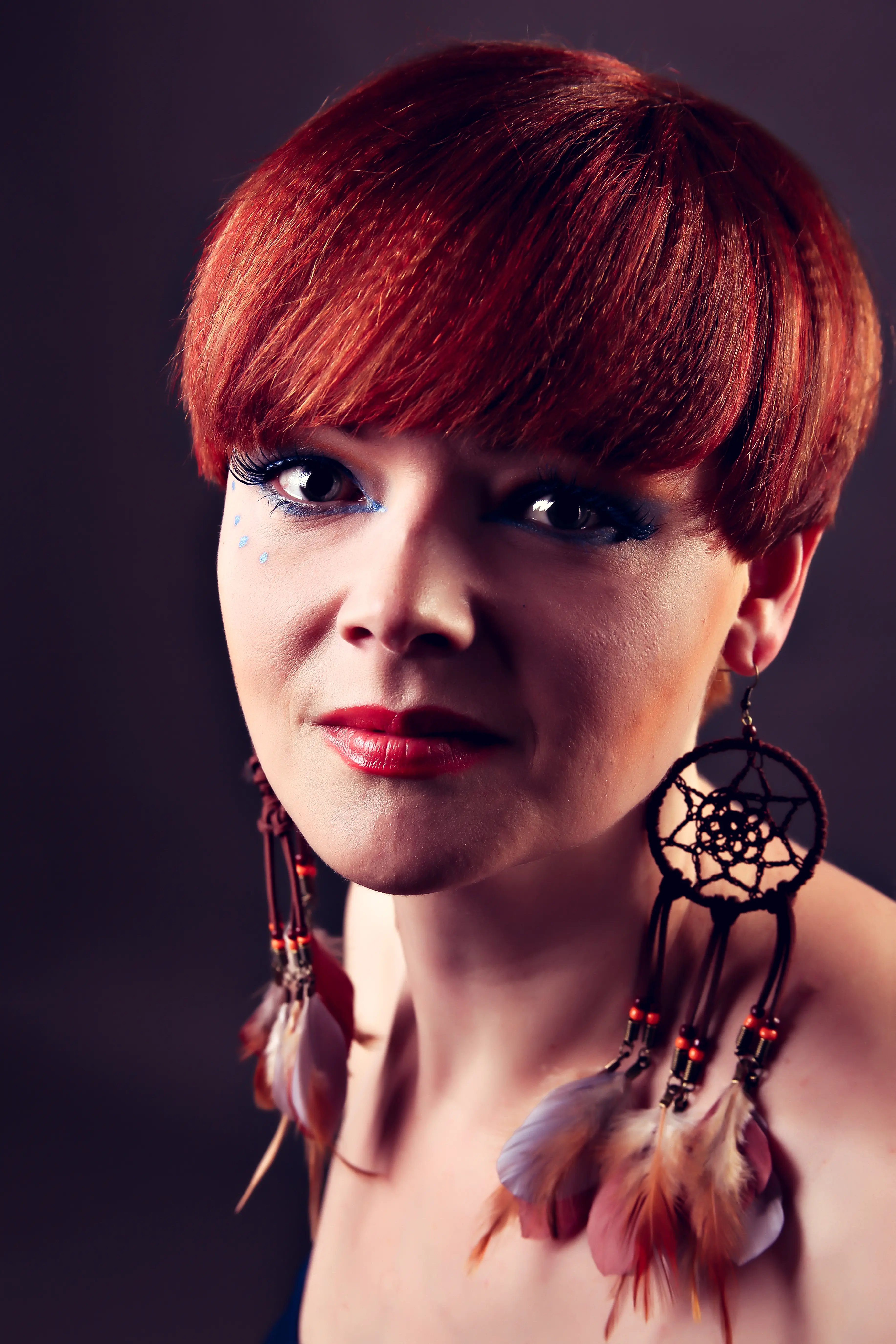 Frau mit rotem Bob und Ohrringen